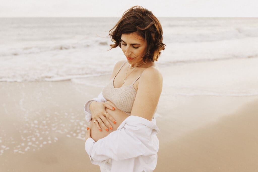Femme enceinte de profil face à la mer, photographe maternité Charente
