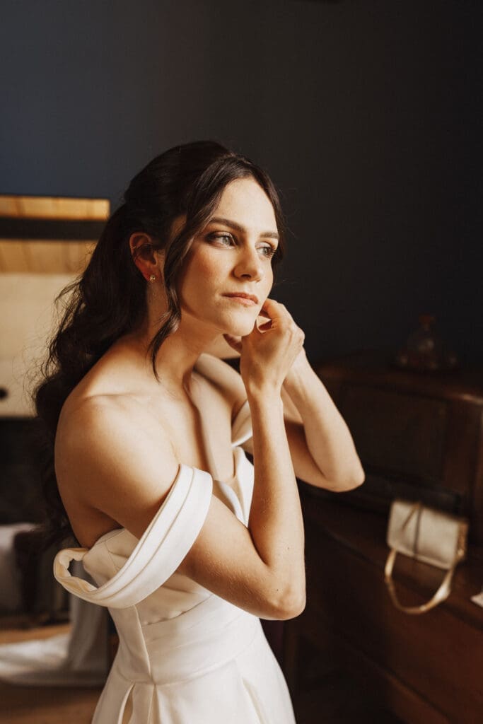 Mariée qui enfile ses bijoux pendant les préparatifs — mariage au Logis des Calices à Jurignac, photographe mariage Charente